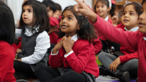 Group of children on the carpet engaged with a RWI Speed Sound lesson.